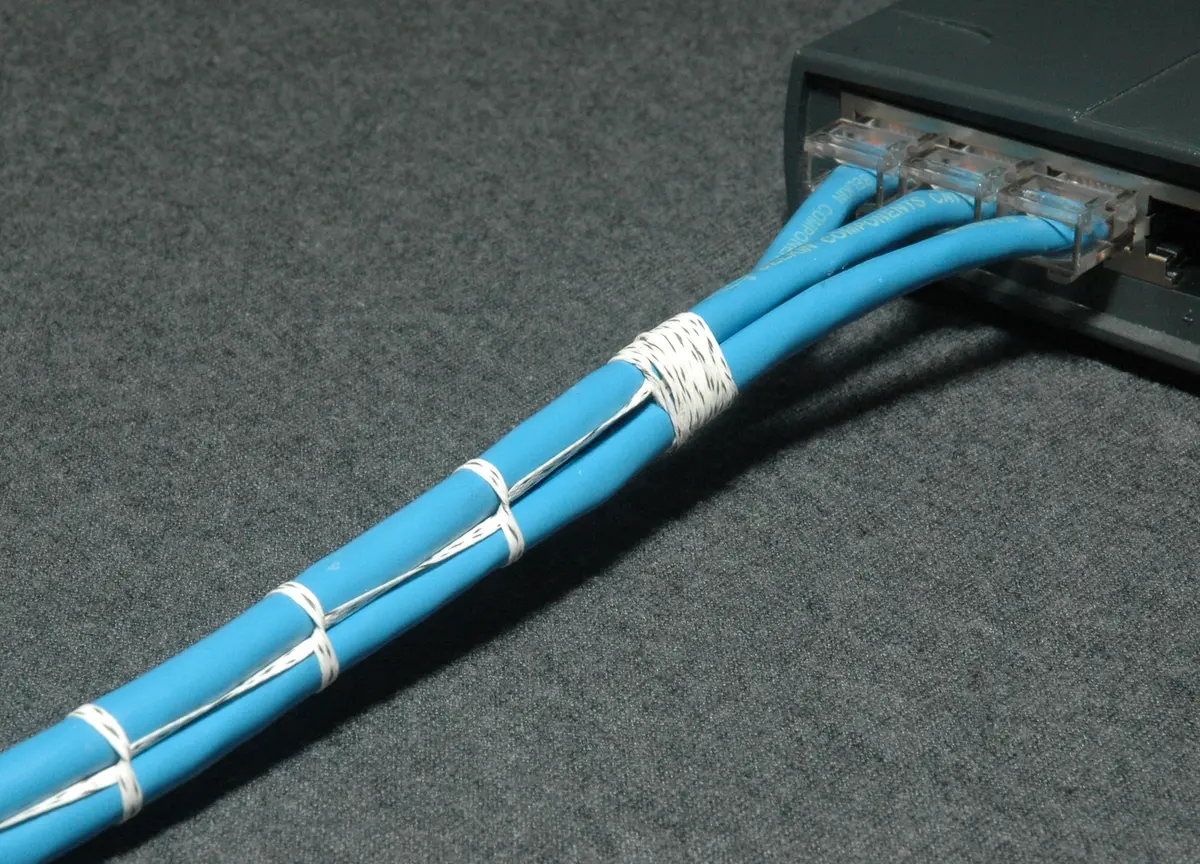 Gebündelte blaue Netzwerkkabel an einem Switch